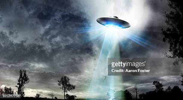 ufo beaming up a man - flying saucer stock illustrations