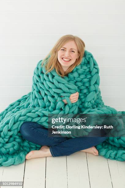 arm knitted turquoise green blanket - wrapped in a blanket stockfoto's en -beelden