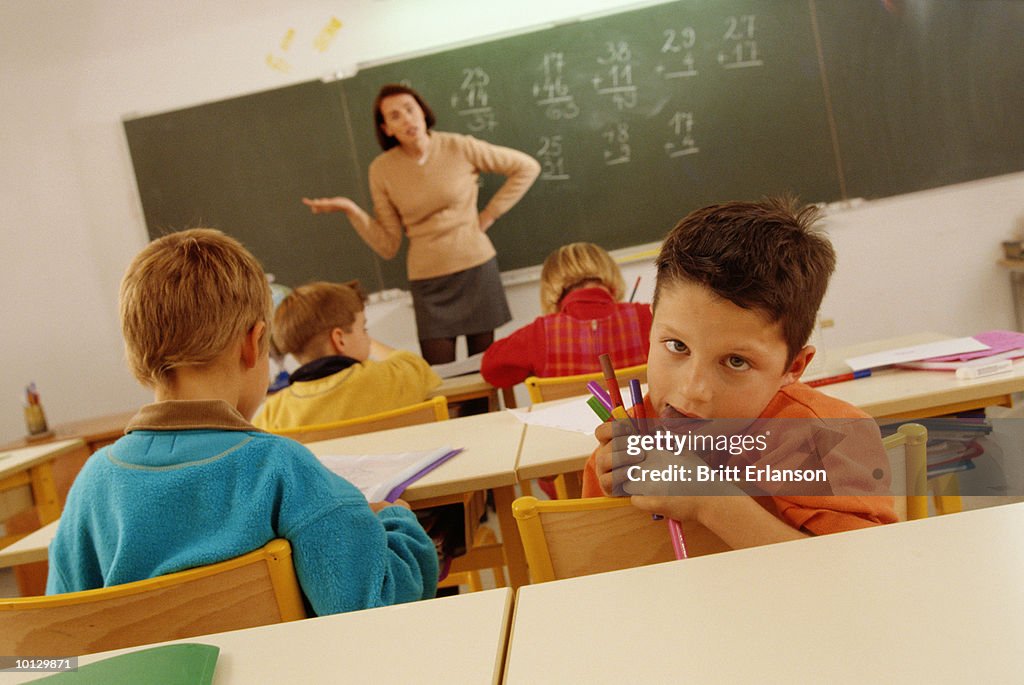 SCHOOLBOY WITH A FUNNY FACE CLASSROOM