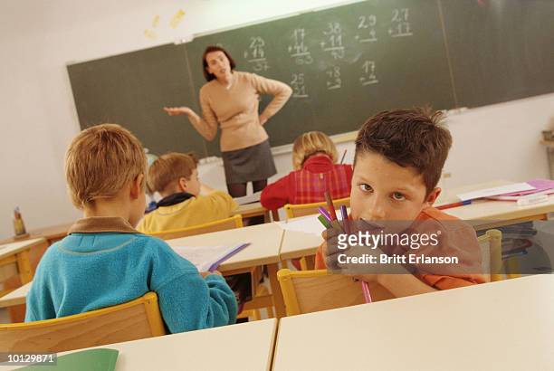 schoolboy with a funny face classroom - wit blackboard - fotografias e filmes do acervo