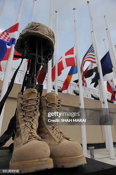 Rifle, helmet and pair of boots lie in respect during a ceremony at Camp Eggers in Kabul on May 31, 2010. US forces based at Camp Eggers gathered for...