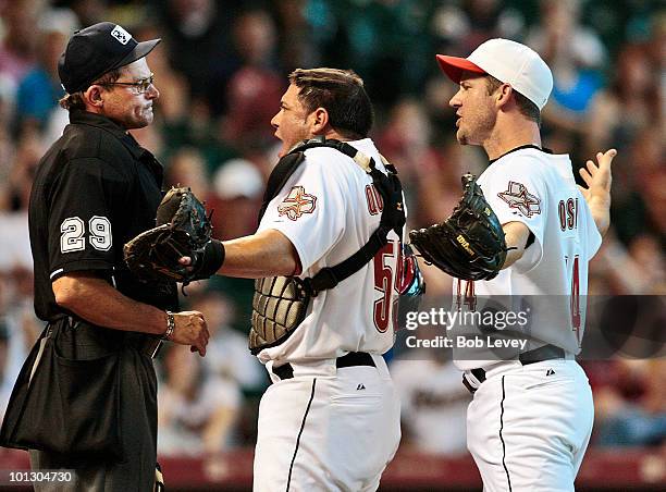 Pitcher Roy Oswalt and catcher Humberto Quintero argue with home plate umpire Bill Hohn after he threw Oswalt out of the game in the third inning...