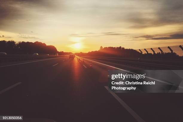 sunset on german highway - street sunset stock-fotos und bilder