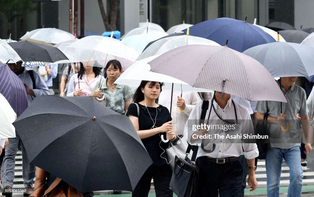Commuters walk with umbrellas as powerful Typhoon Shanshan approaches Commuters walk with umbrellas as powerful Typhoon Shanshan approaches