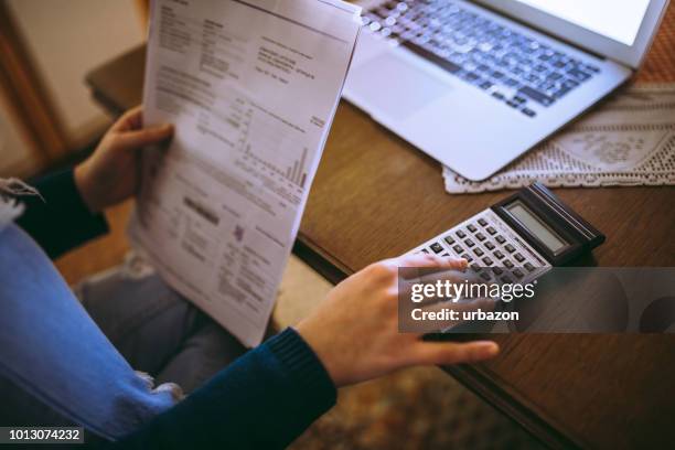 woman calculating bills with calculator - accounting stock pictures, royalty-free photos & images