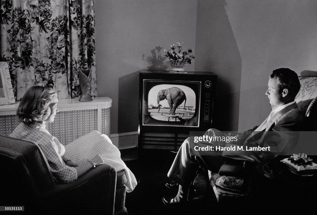 COUPLE WATCHING TV IN 1955 LIVING ROOM