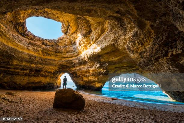 solitary man inside the benagil caves, portugal - wonderlust imagens e fotografias de stock