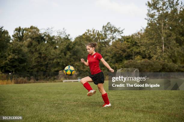 side view of girl kicking soccer ball on field - 11-13 2017 stock pictures, royalty-free photos & images