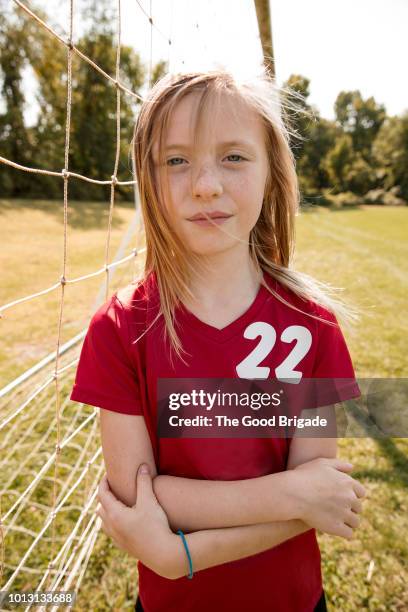 portrait of girl standing on soccer field - female blonde blue eyes stock-fotos und bilder