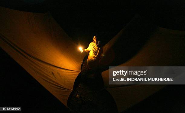 Homeless Kashmiri woman calls out to her child as she gets ready to spend the night inside a tent at a open field in Uribala village of Uri province...