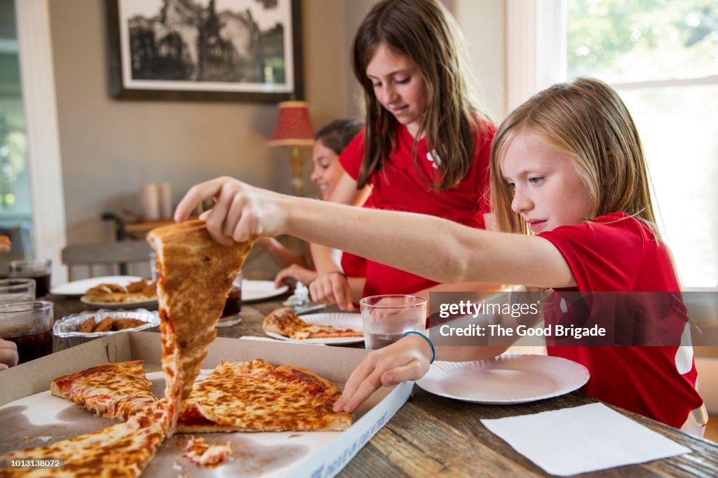Girls soccer team eating pizza