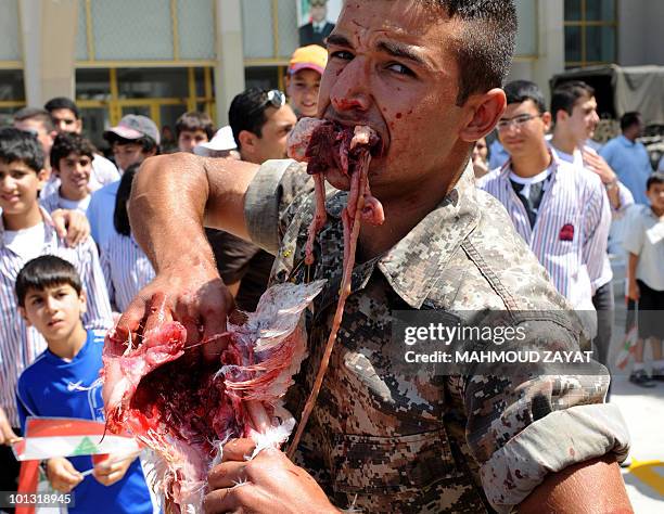 Lebanese commando kills a chicken during a demonstration by the Lebanese Army to students at a school in the southern port city of Sidon on May 26,...