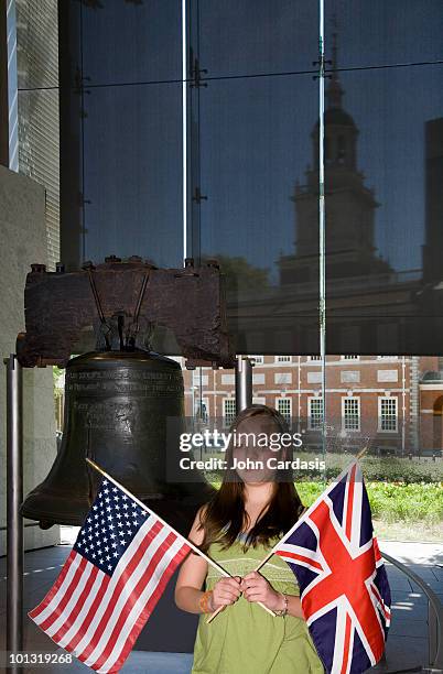 young girl standing next to the liberty bell - liberty bell flag stock pictures, royalty-free photos & images