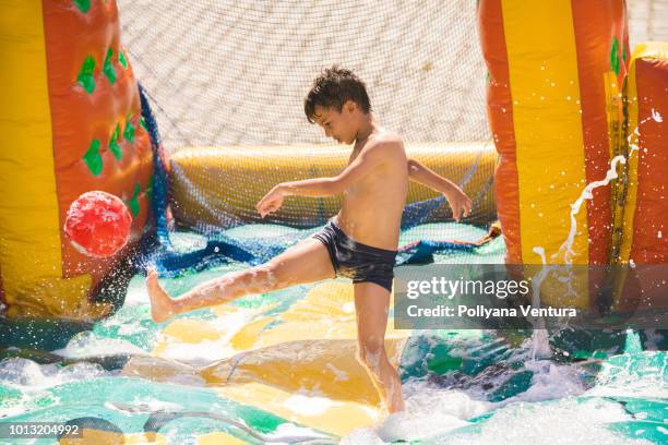 boy kicking ball in inflatable foam pool - blocked kick stock pictures, royalty-free photos & images