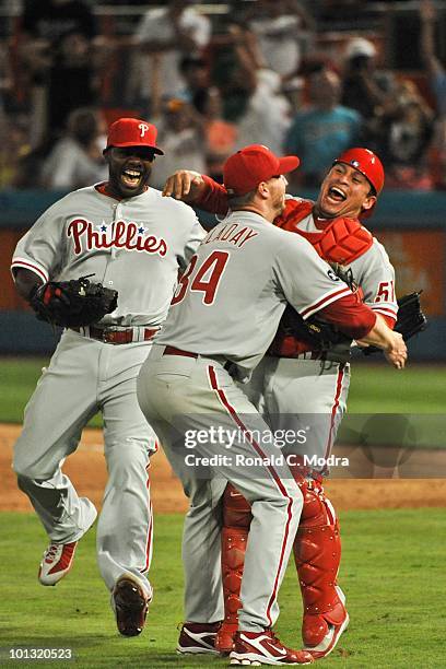 Pitcher Roy Halladay of the Philadelphia Phillies pitches celebrates with teammates Carlos Ruiz and Ryan Howard after pitching a perfect game against...