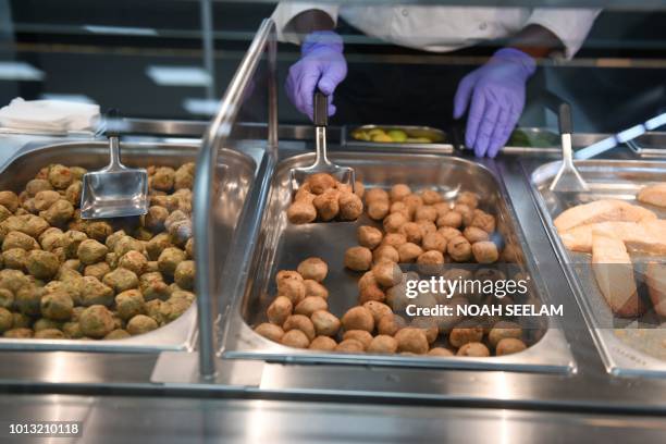 Indian worker prepare to serve chicken meatballs to guest at the restaurant section of the new IKEA store in Hyderabad on August 8, 2018. - Ikea's...