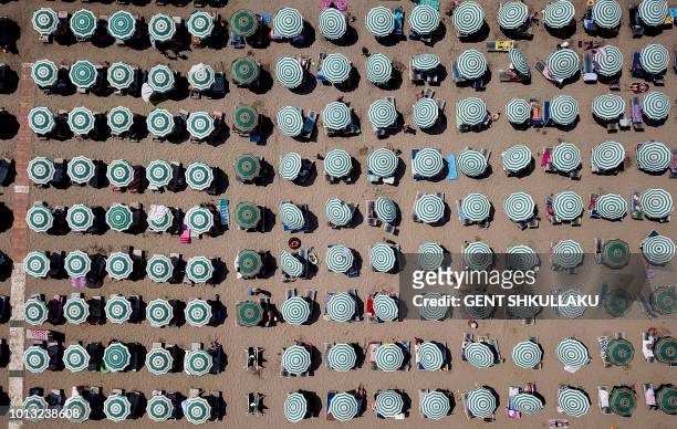 This aerial photograph shows parasols on a beach of the Adriatic Sea on August 8, 2018 in Durres, as a heatwave sweeps across Europe. Temperatures...