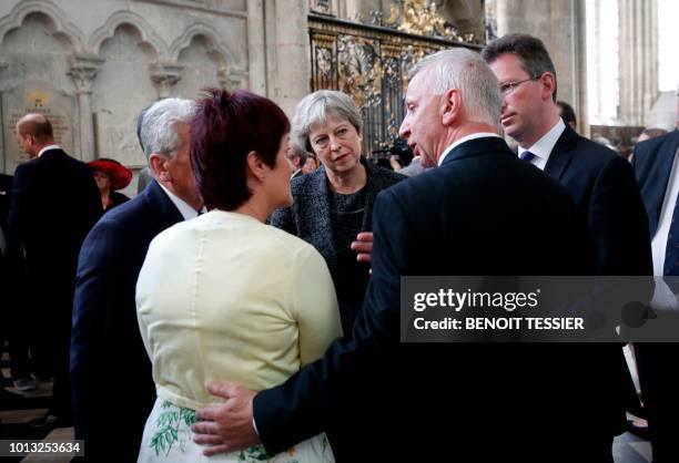 Britain's Prime Minister Theresa May speaks with relatives of soldiers who took part in the Battle of Amiens after a religious ceremony to mark the...