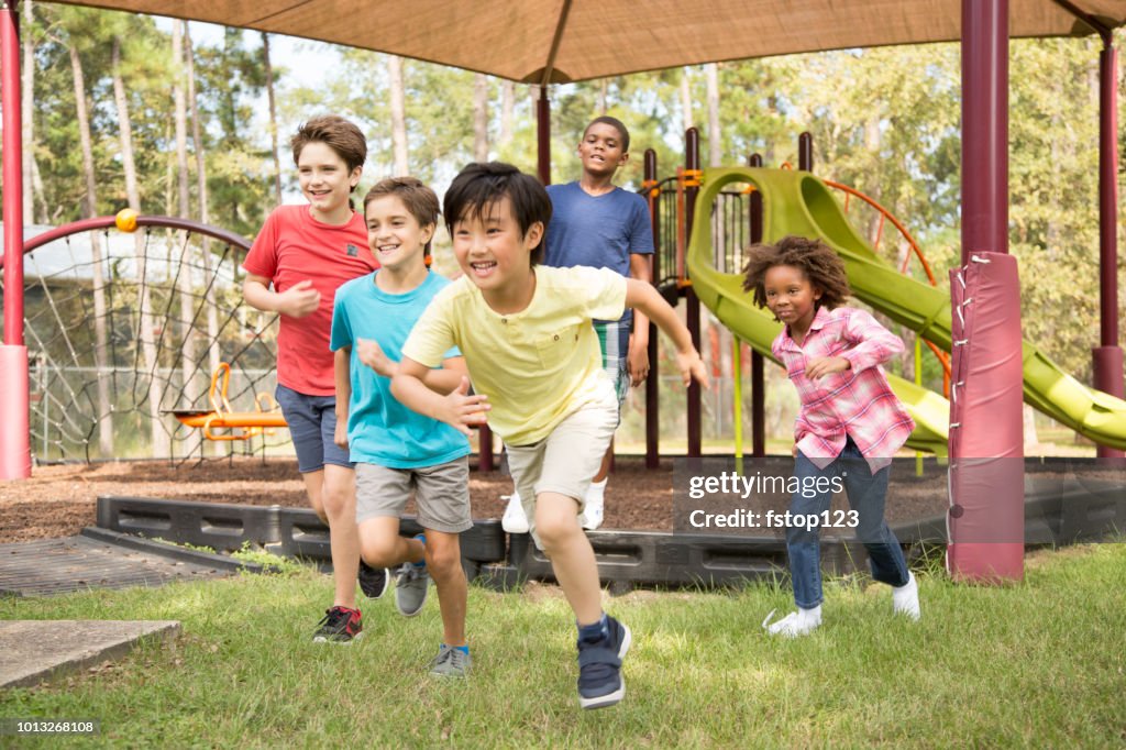 Grupo multiétnico de los escolares en el patio de la escuela.