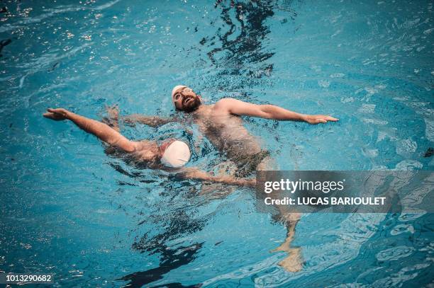 Participants compete during the synchronized swimming contest during the 10th edition of the international Gay Games at the Maurice Thorez swimming...