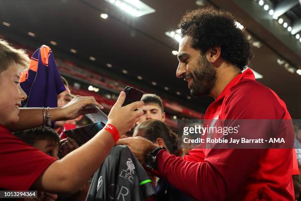 Mohamed Salah of Liverpool signs autographs for fans during the pre-season friendly between Liverpool and Torino at Anfield on August 7, 2018 in...
