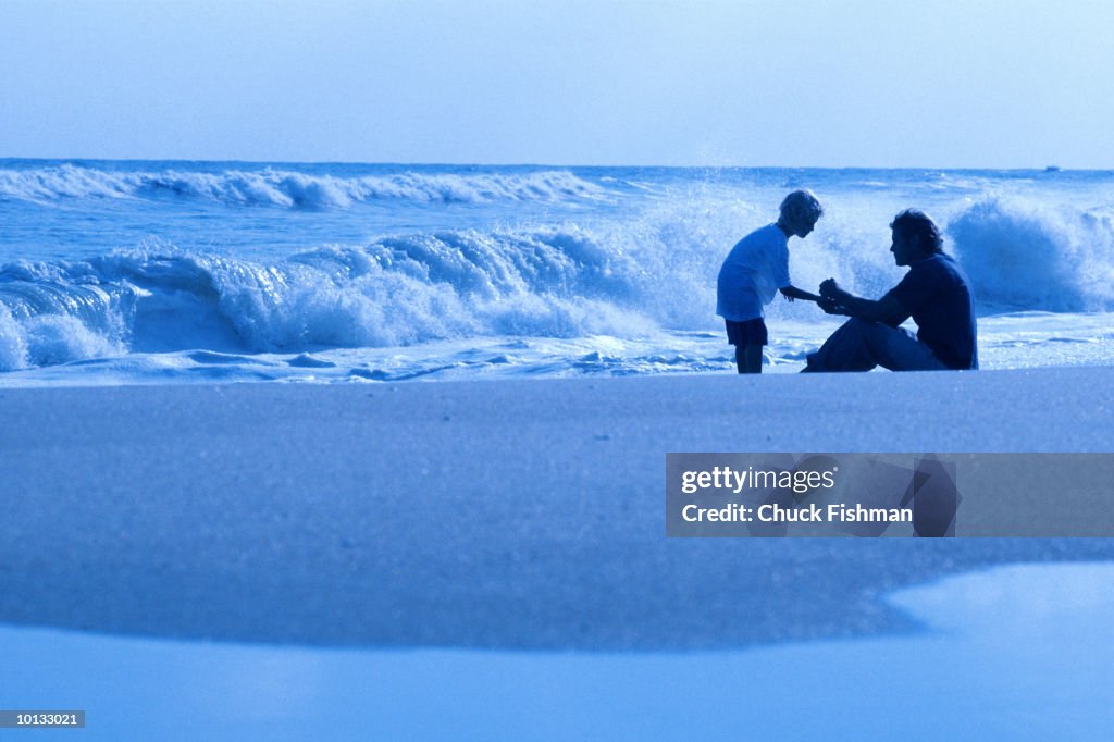 FATHER AND SON ON BEACH IN WAVES, LONG ISLAND, NEW YORK