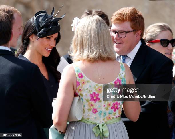 Meghan, Duchess of Sussex talks with Celia McCorquodale and George Woodhouse as she attends the wedding of Charlie van Straubenzee and Daisy Jenks at...