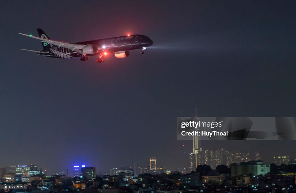 Air New Zealand airplane boeing 777 in All Blacks livery landing at Tan Son Nhat International Airport at night in Ho Chi Minh City, Vietnam.