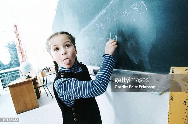girl on blackboard, funny faces - spoilt children stock-fotos und bilder