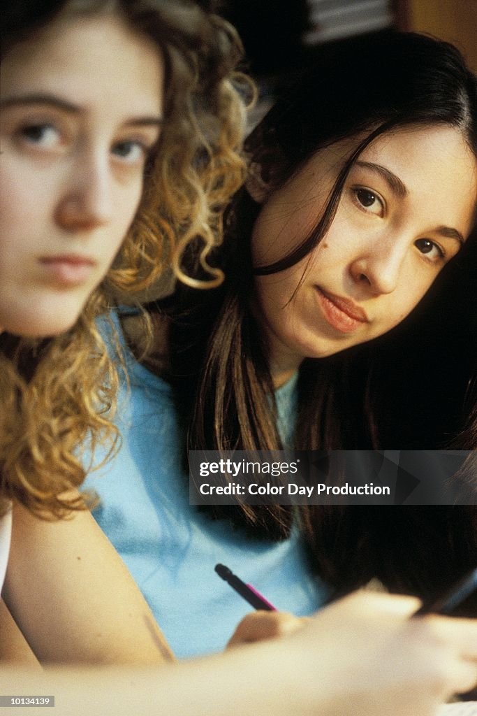 TEEN GIRLS STUDYING, HOME