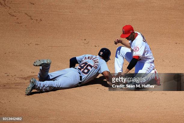 Jeimer Candelario of the Detroit Tigers dives back to second base as Andrelton Simmons of the Los Angeles Angels of Anaheim applys the tag in a pick...