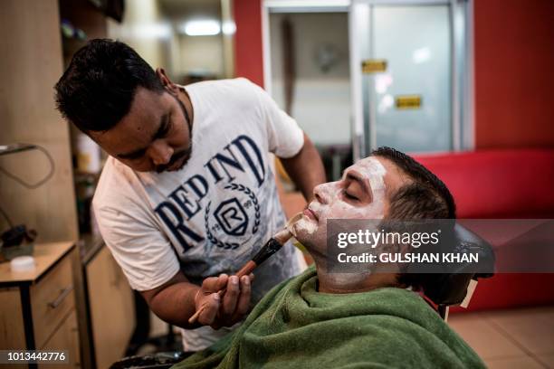 Aasif Khalifa applies a mask on Himesh Dhulab as part of a facial which used skin lightening products at the Pari Hair Salon in the Fordsburg suburb...