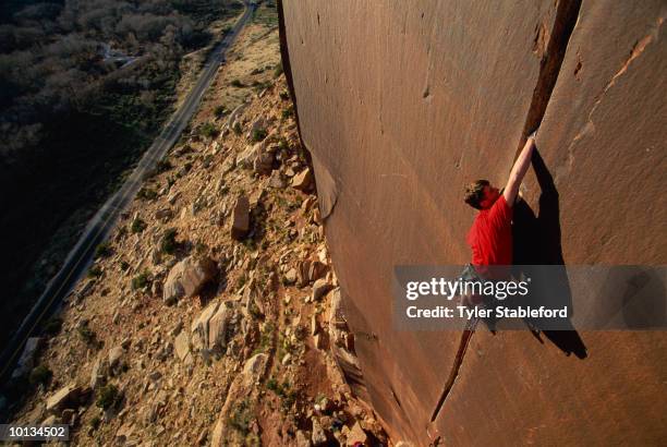 male climber on vertical crack,canyonlands, ut - soloklettern stock-fotos und bilder