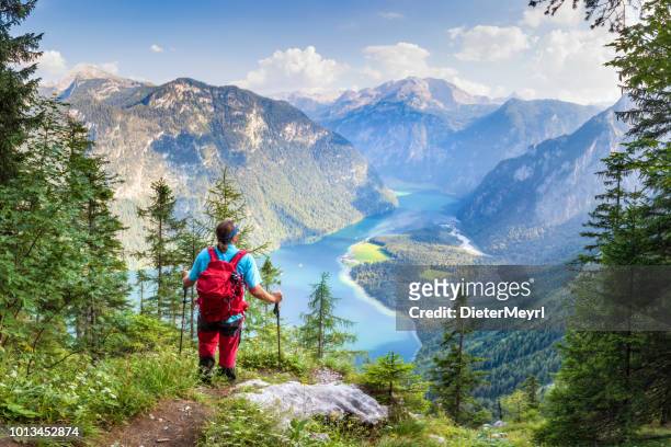 wanderer mit blick auf lake königssee und st. bartholomä, nationalpark berchtesgaden - berchtesgaden stock-fotos und bilder