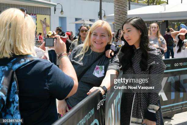 Awkwafina poses with a fan at "Extra" at Universal Studios Hollywood on August 8, 2018 in Universal City, California.