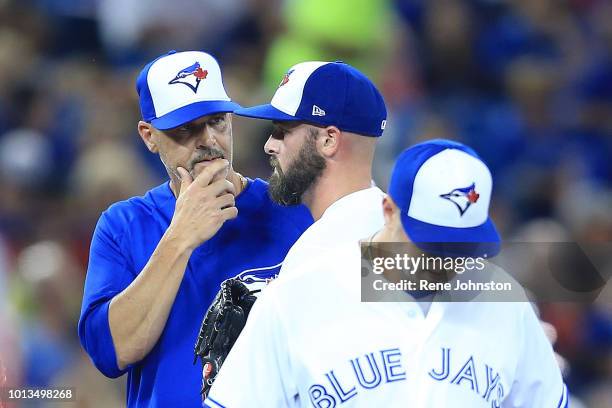 Toronto Blue Jays pitching coach Pete Walker talks to Mike Hauschild after hitting Rafael Devers of the Boston Red Sox in the third. He was pulled...