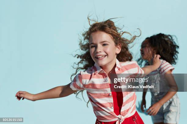 girl running with arms out, on studio background - girl laughing photos et images de collection