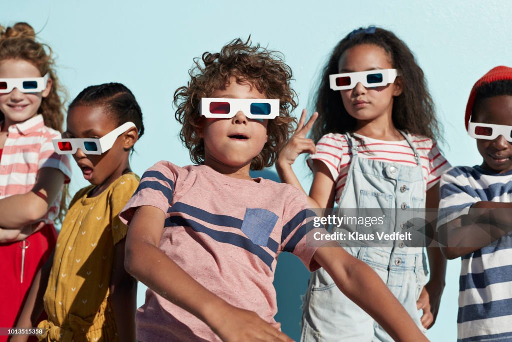 Group shot of cool kids wearing 3-D glasses while playing and posing