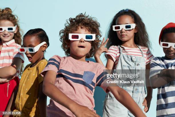 group shot of cool kids wearing 3-d glasses while playing and posing - tough love stockfoto's en -beelden