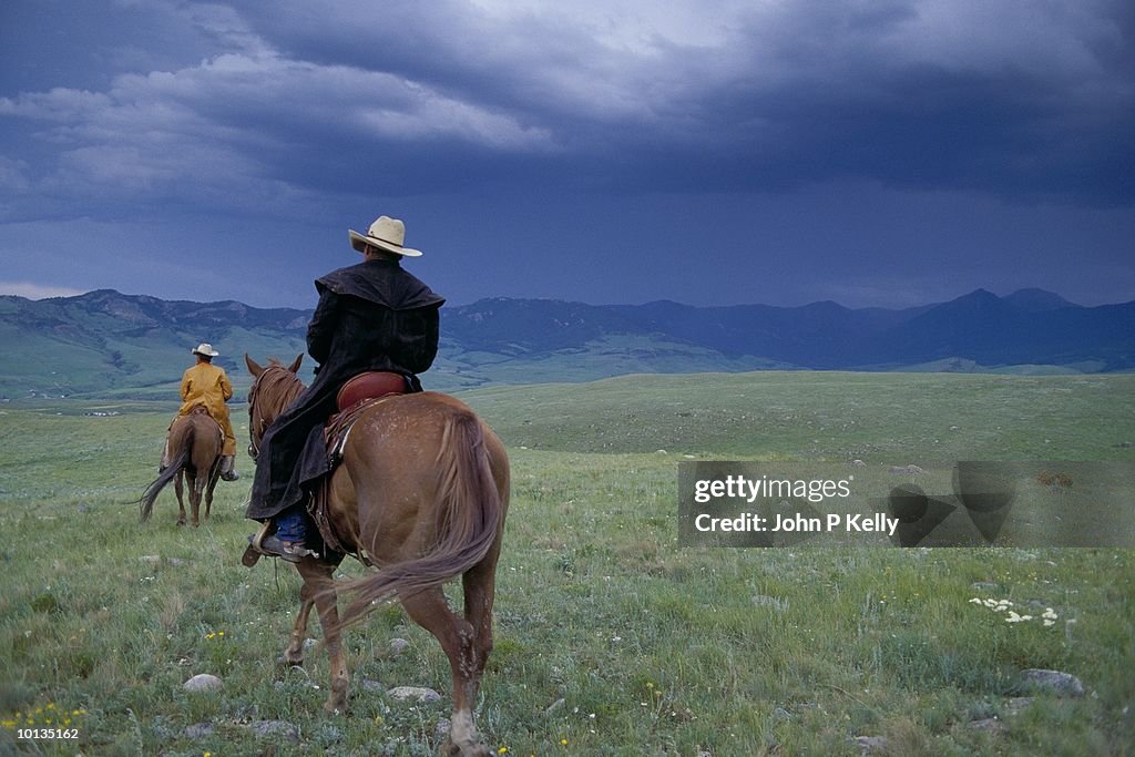 TWO COWBOYS RIDING THE RANGE IN MONTANA