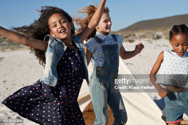 cute girls laughing & dancing together on the beach - children dancing outside stockfoto's en -beelden