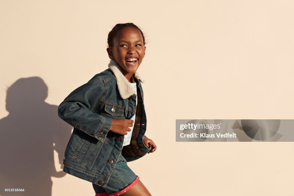 Portrait of cute girl laughing, on studio background