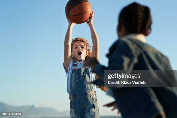 children together playing on beach by the ocean - basketball player stock-fotos und bilder