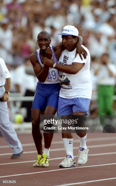 Derek Redmond of Great Britain is helped towards the finish line by his father Jim Redmond after suffering an injury in the 400m semi-final at the...