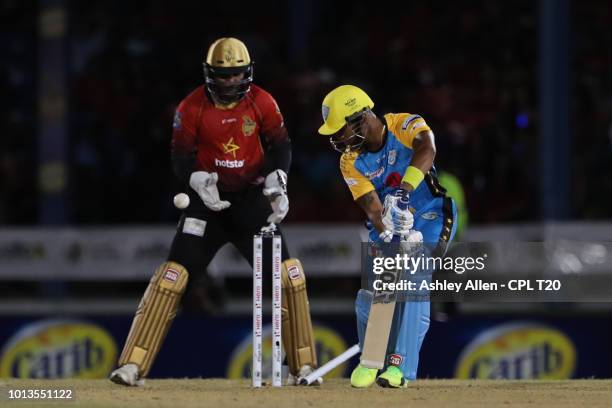 In this handout image provided by CPL T20, Lendl Simmons of St Lucia Stars is bowled as Denesh Ramdin of Trinbago Knight Riders looks on during the...