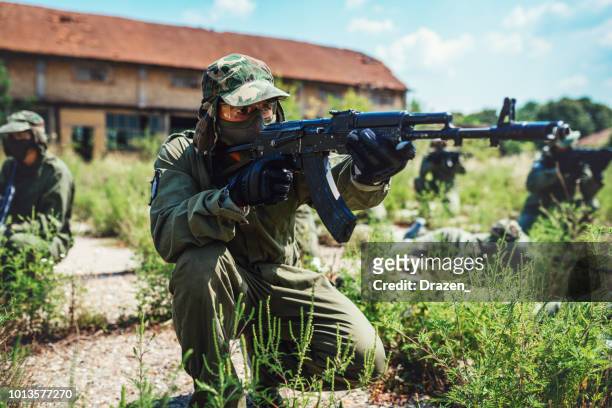 friends playing warfare games on the battlefield - airsoft gun stock pictures, royalty-free photos & images