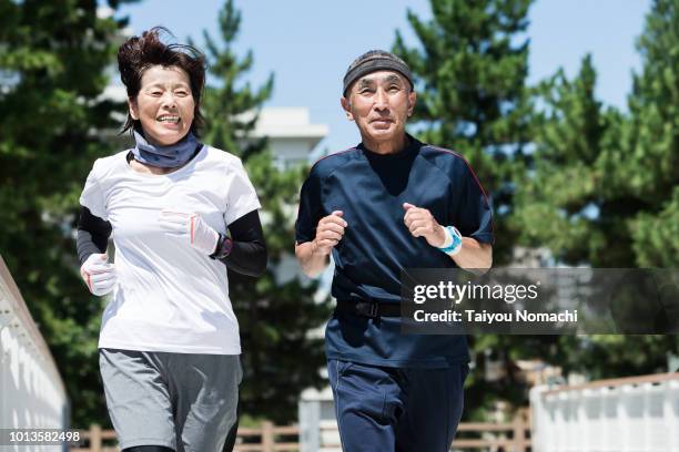 senior generation enjoying jogging with men and women - japanese senior couple bildbanksfoton och bilder