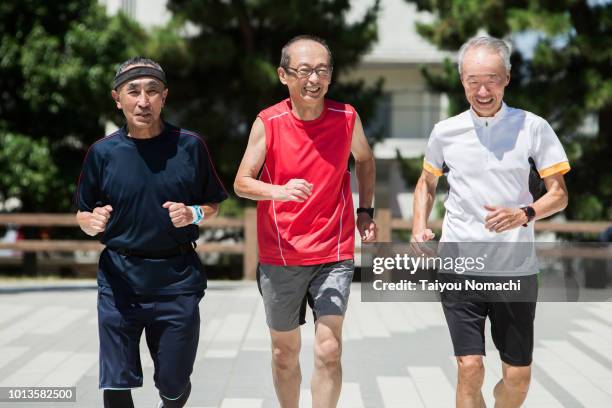 senior men enjoying jogging with friends - japanese old man foto e immagini stock