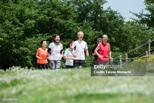 seniors who jog together with men and women - active retirement community stock pictures, royalty-free photos & images