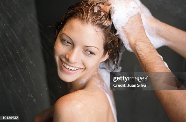 woman getting shampoo by man in shower - shower man woman washing stock pictures, royalty-free photos & images